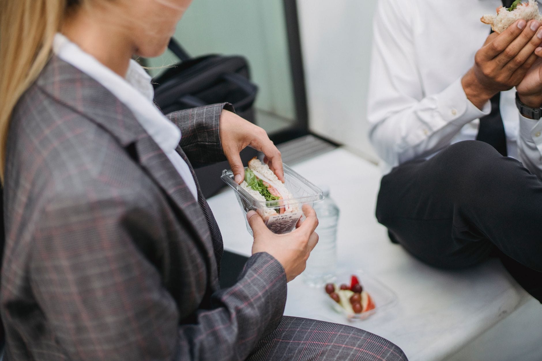 Pracownicy biurowi jedzą kanapki podczas przerwy na lunch